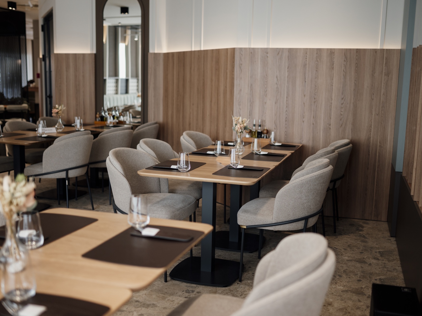 Warmer, eleganter Restaurantbereich mit eingedeckten Holztischen